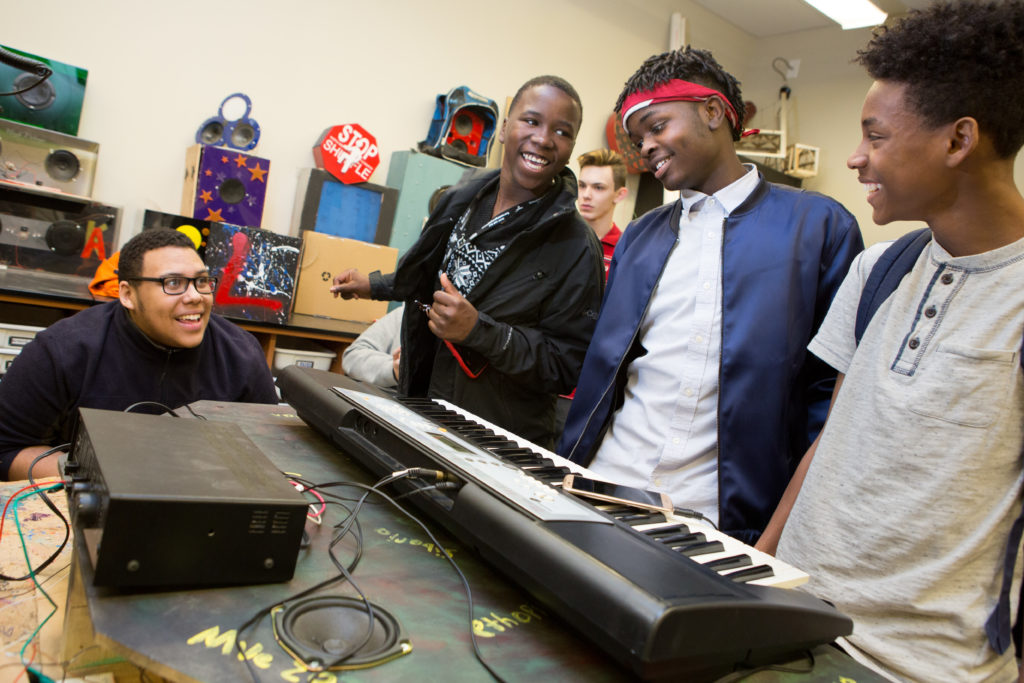 A group of ninth graders rehearse for an upcoming communications project.